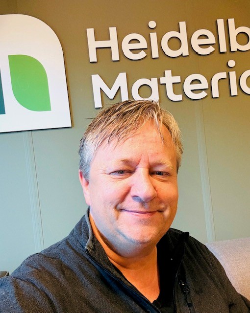 Person foran en vegg med logoen til Heidelberg Materials synlig i bakgrunnen.